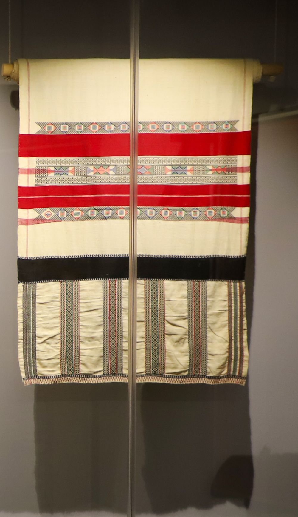 Toda poothkuli shawl showing red and black counted-thread embroidery bands, National Crafts Museum, New Delhi